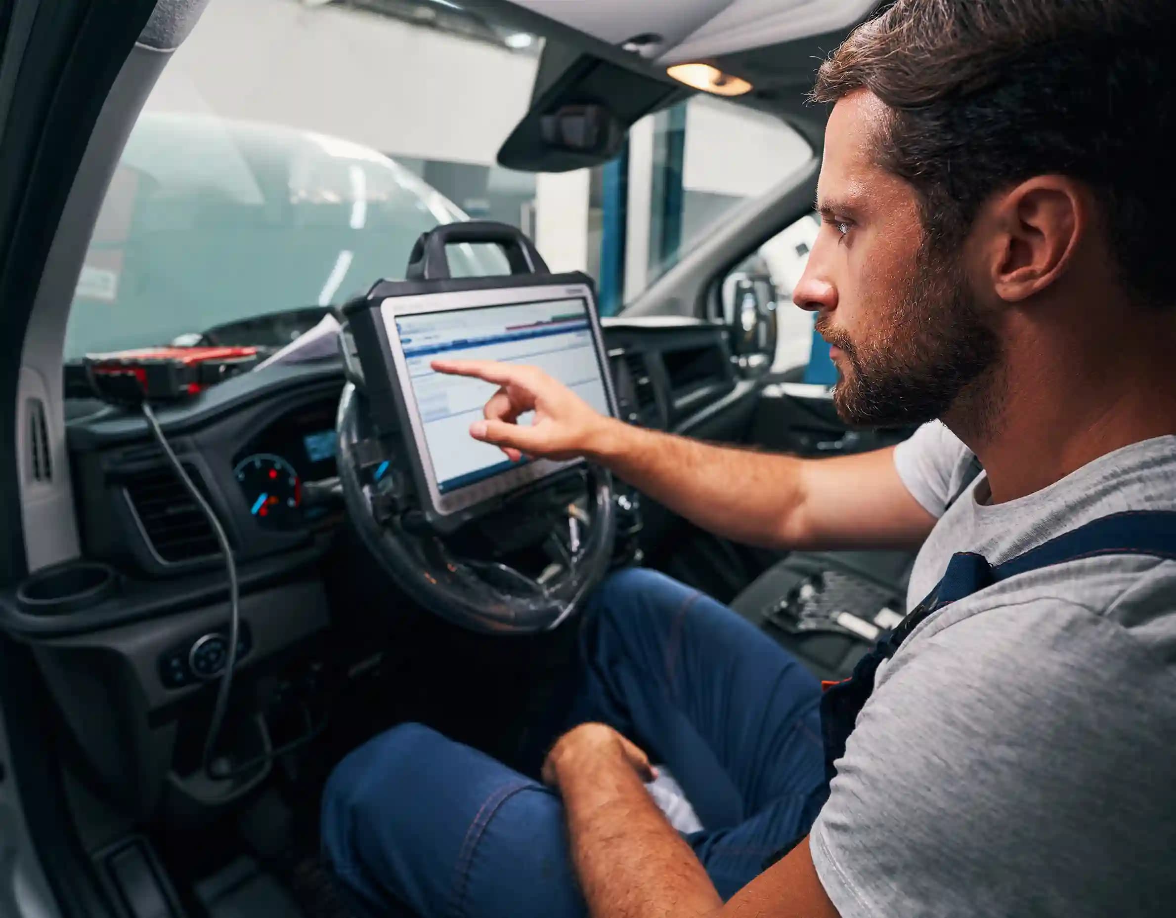 Technician performing ADAS camera calibration on vehicle windscreen in Essendon Melbourne workshop